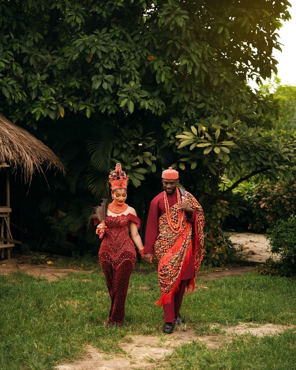Os noivos de mãos dadas a caminhar no jardim