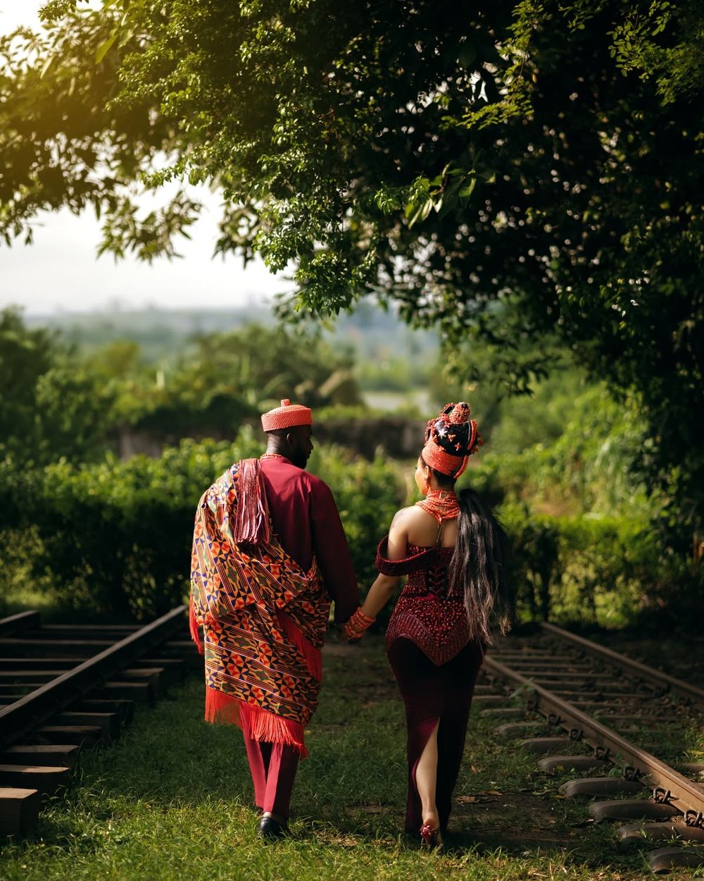 Os noivos de costas, de mãos dadas, a caminhar entre as árvores